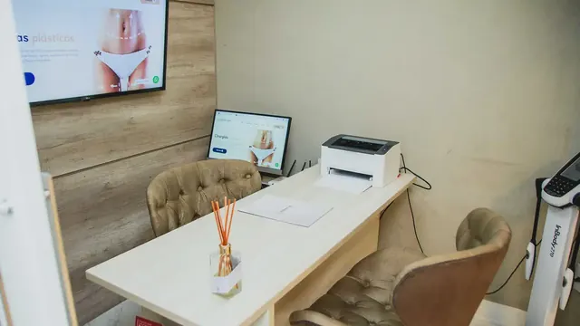 Consultório de avaliação com mesa e poltronas