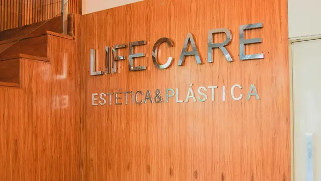 Painel de madeira com o nome Lifecare na entrada da clínica