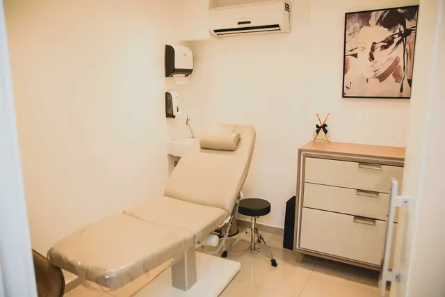 Sala de procedimentos com maca e armário em tons claros